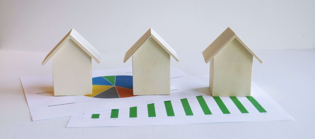 Tres-casas-sobre-gráficos-financieros-para-analizar-compra-de-una-segunda -vivienda-en-España